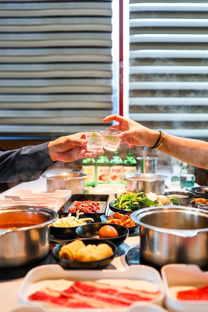 Buffet-style hot pot ingredients arranged near the dining area.